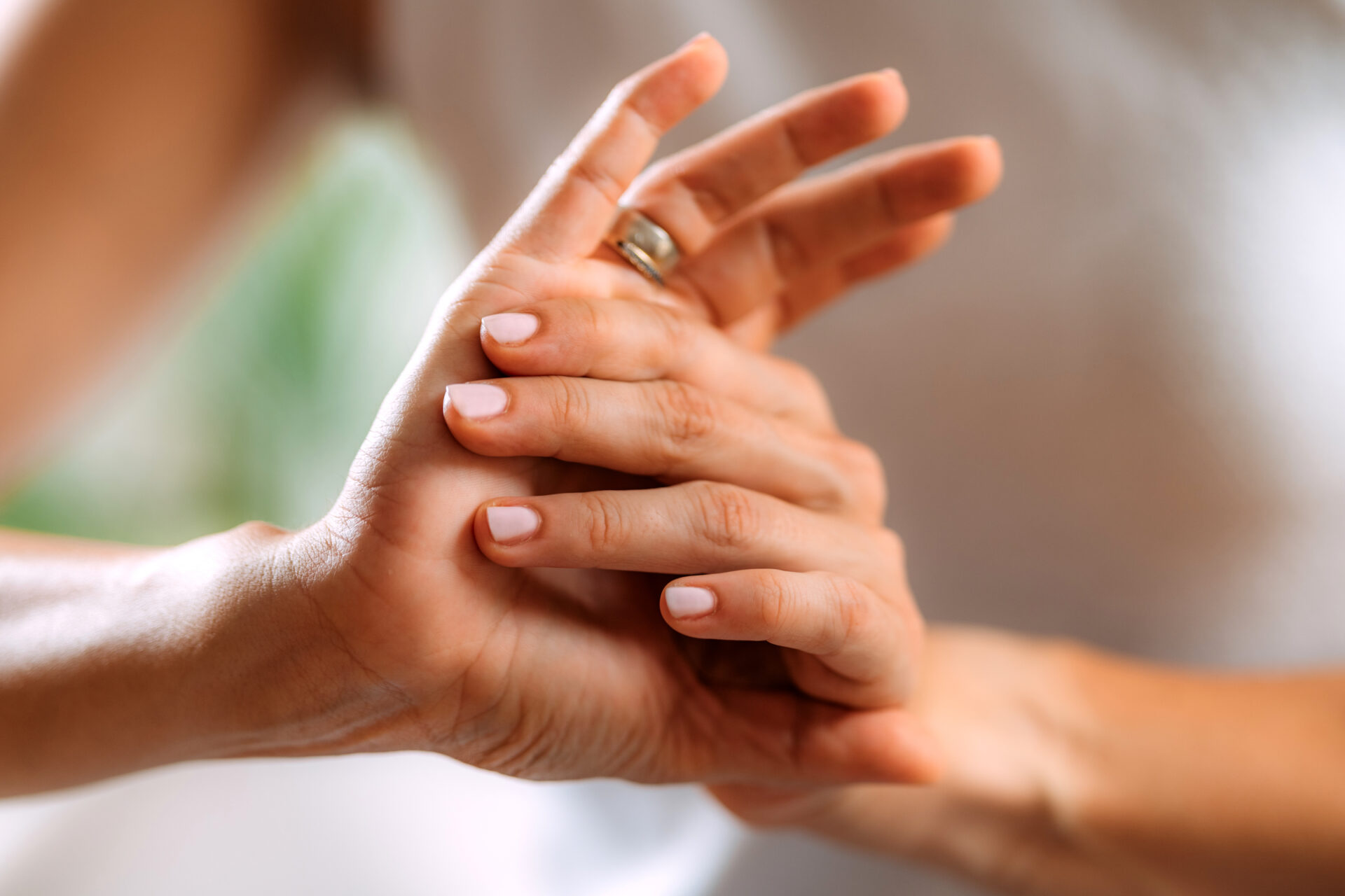 unrecognizable female rubbing hands together gently as if from pain
