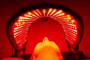 Administering red light therapy for skin rejuvenation with a special contoured mask.