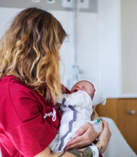 a mother holding a newborn after giving birth, red light therapy after c-section