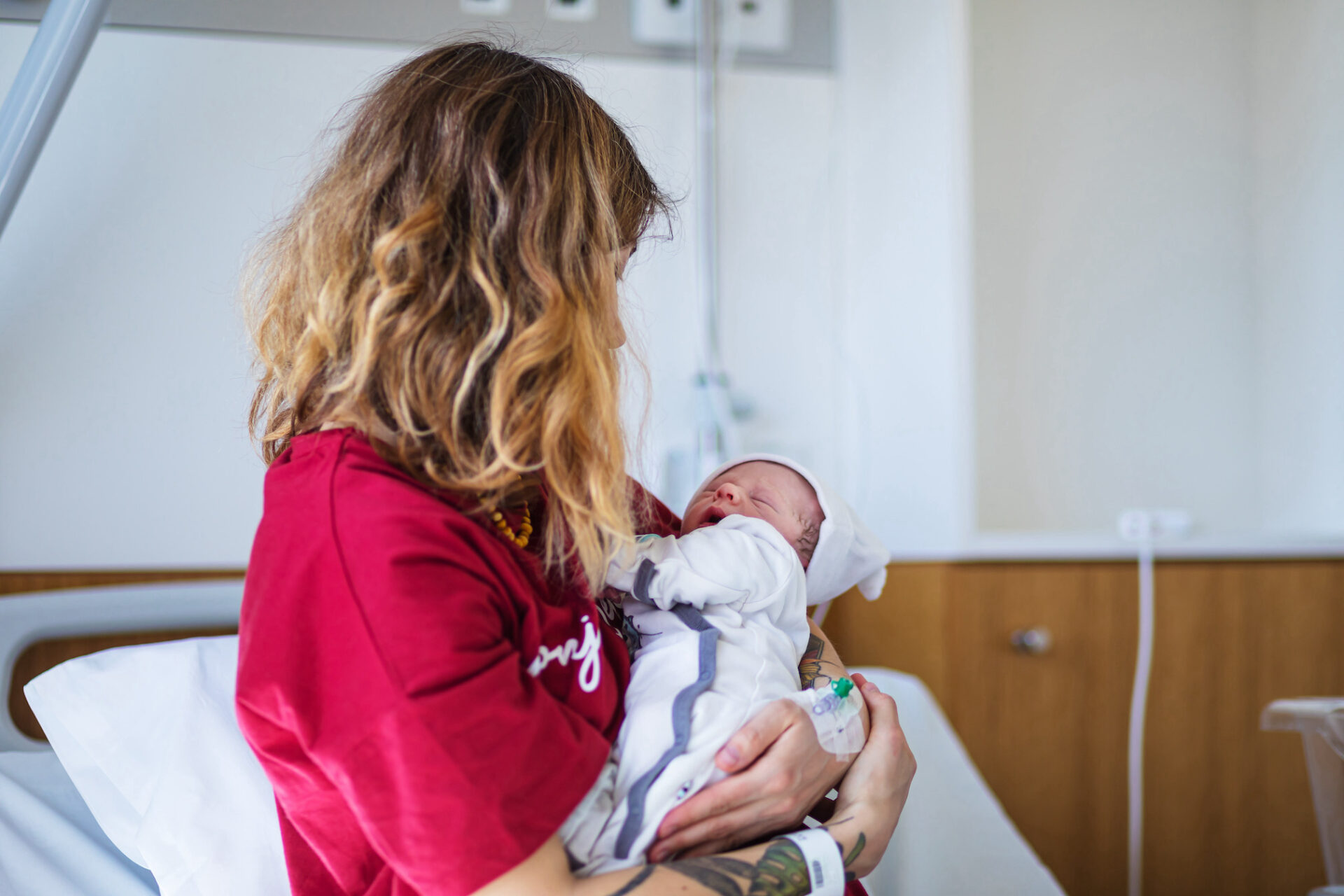 a mother holding a newborn after giving birth, red light therapy after c-section
