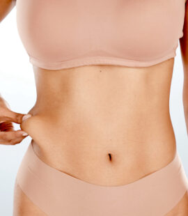 a woman showing off her weight loss from the belly area, a good candidate for red light therapy for loose skin